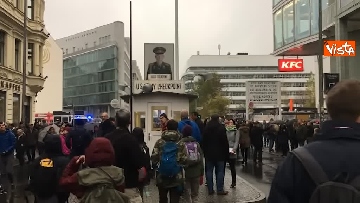 3 - Muro Berlino, festa al Checkpoint Charlie, studenti internazionali rompono muro di carta